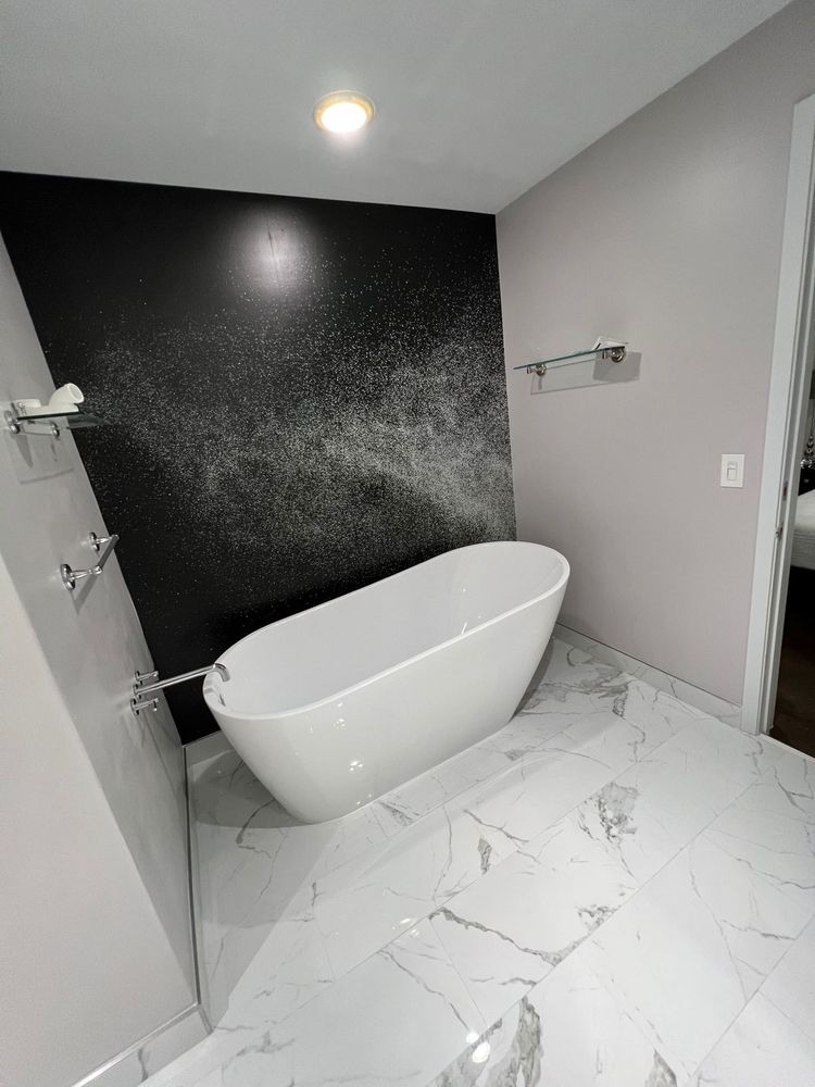 Modern bathtub with black accent wall