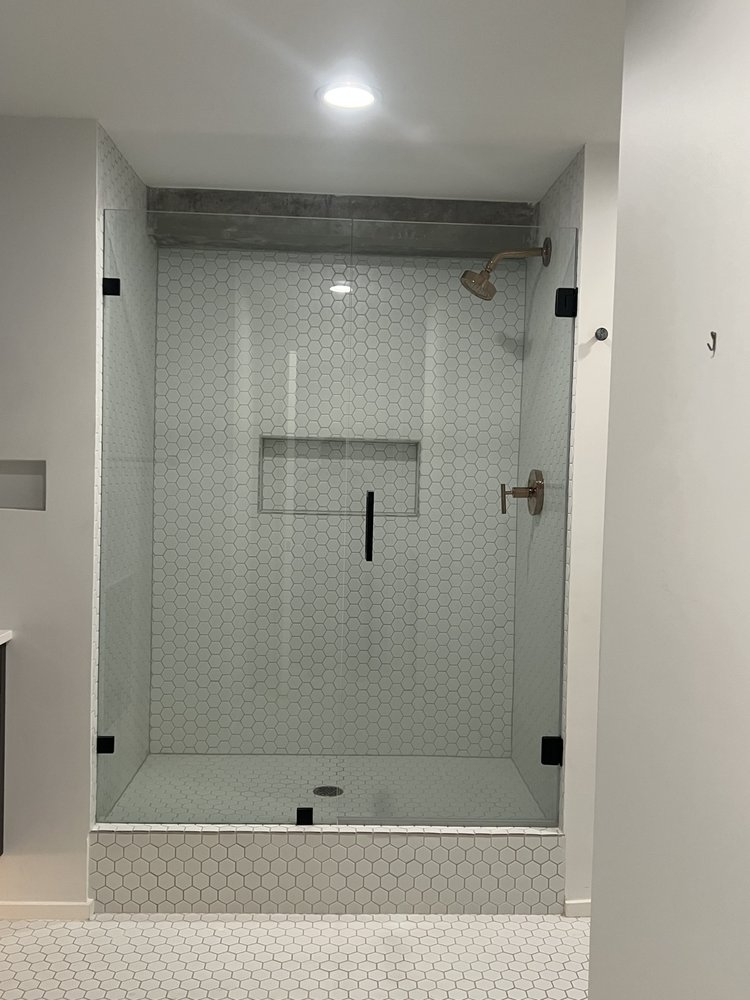 Custom hexagon-tile walk-in shower with glass enclosure